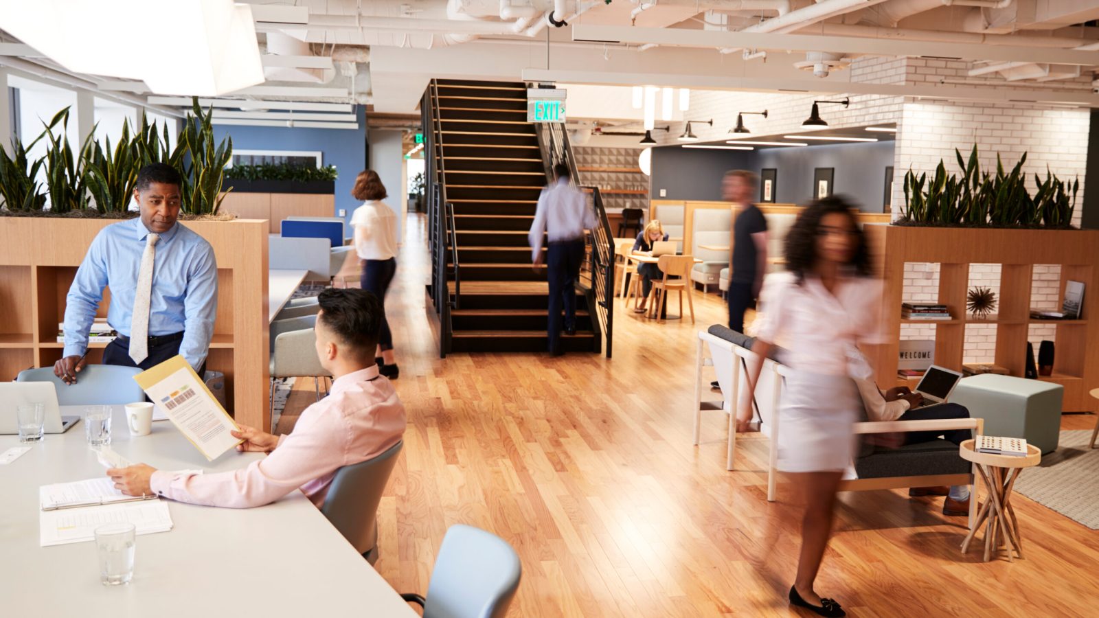 Interior View Of Modern Open Plan Office With Blurred Businessmen And Businesswomen