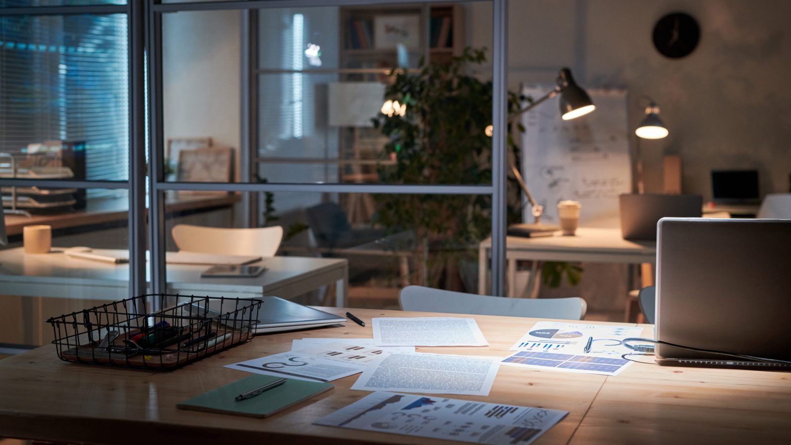 Modern workplace of business person with financial documents and laptop for work in dark office