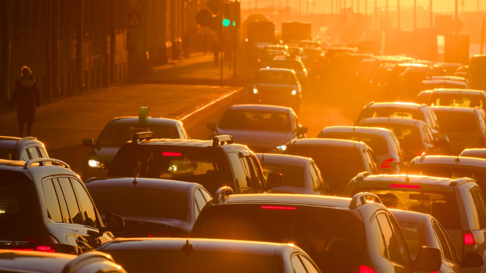 Cars are in a traffic jam during a beautiful golden sunset in a big sity.